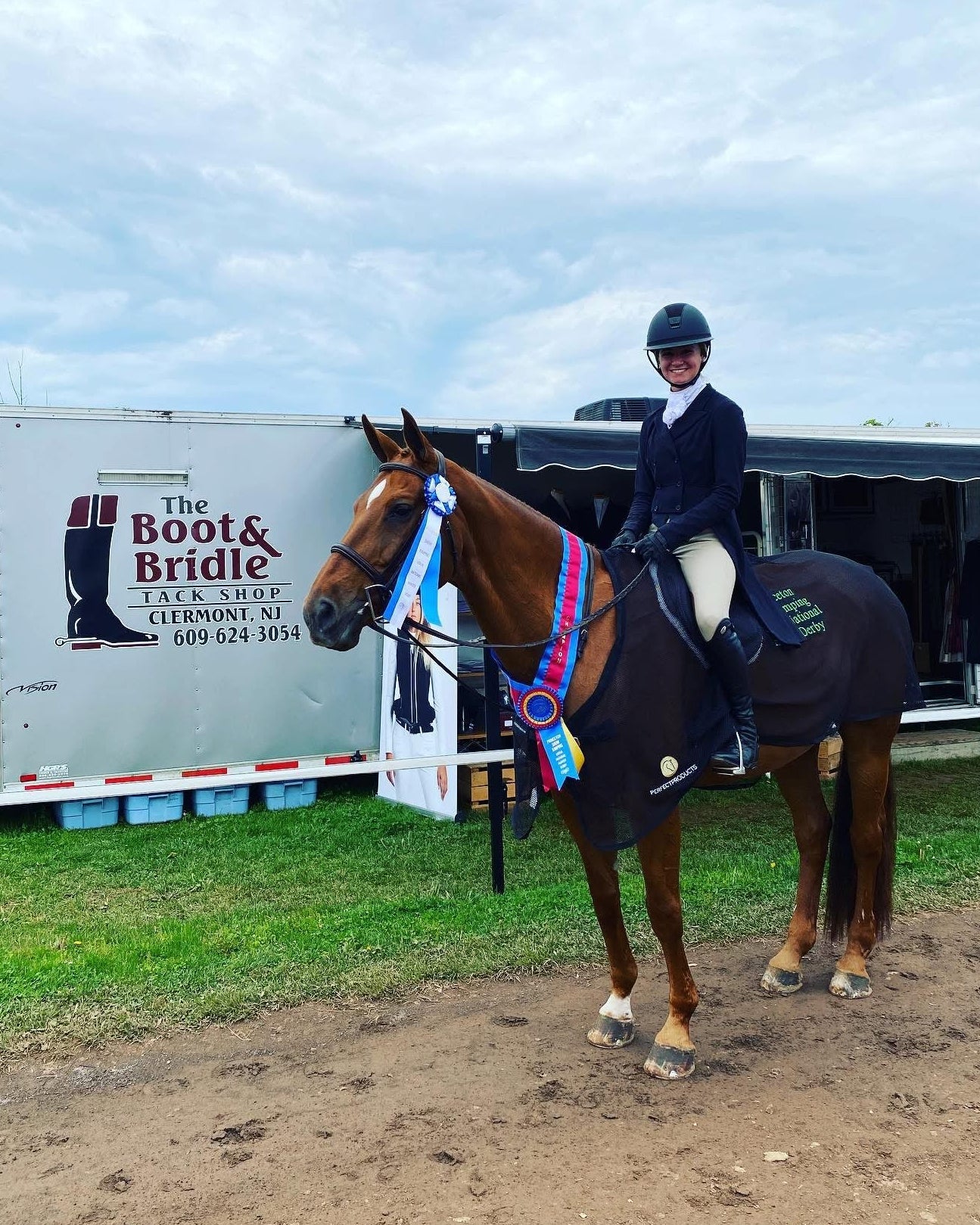 Person on a horse in front of a trailer with 'The Boot & Bridle' logo.